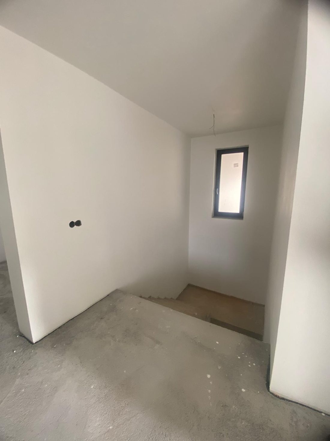 Zona de trecere înainte de amenajare, cu pereți netencuiți și șapă la vedere